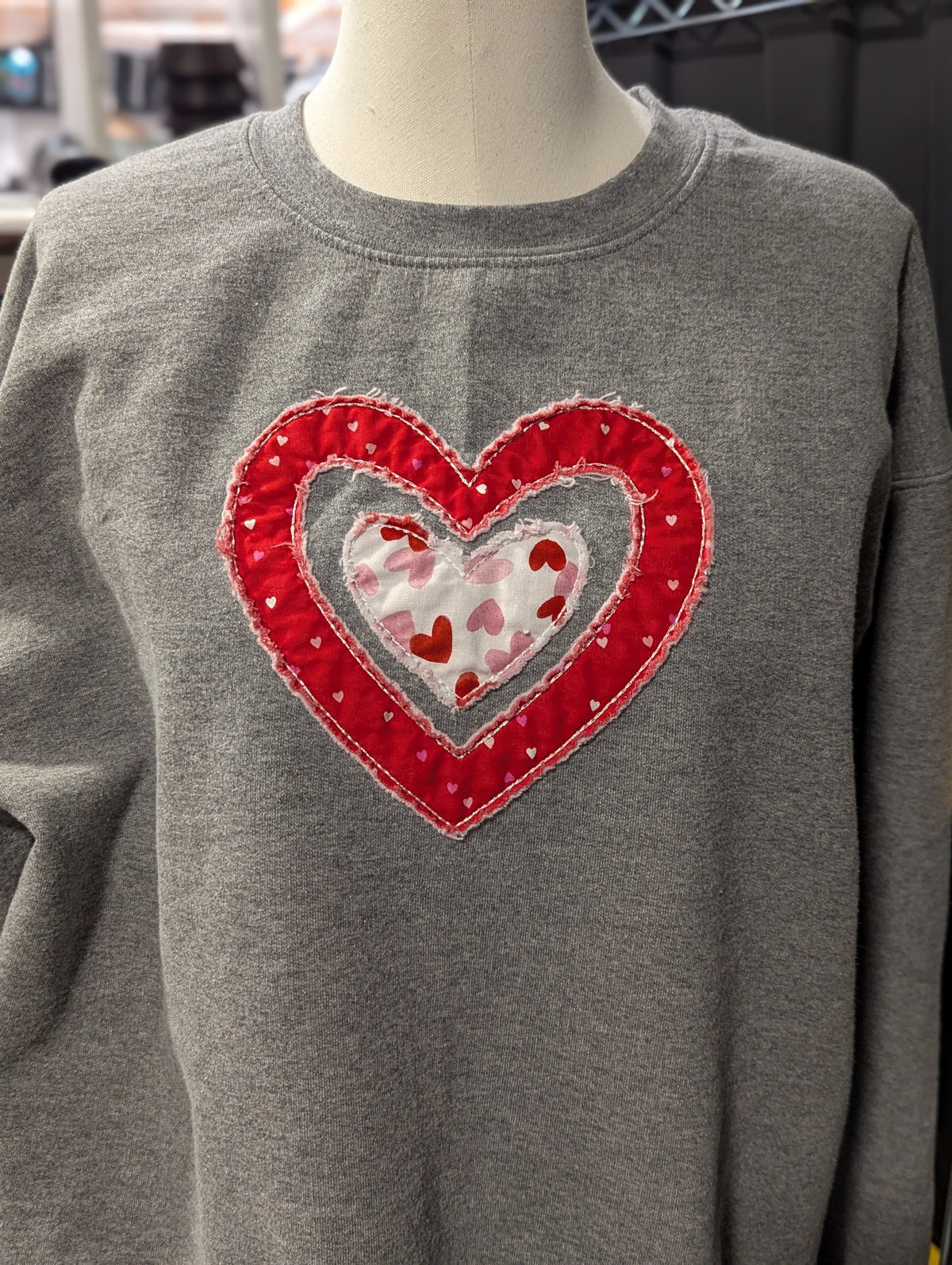 Woman wearing pink embroidered heart sweatshirt from Twist & Thread Co. Valentine's collection