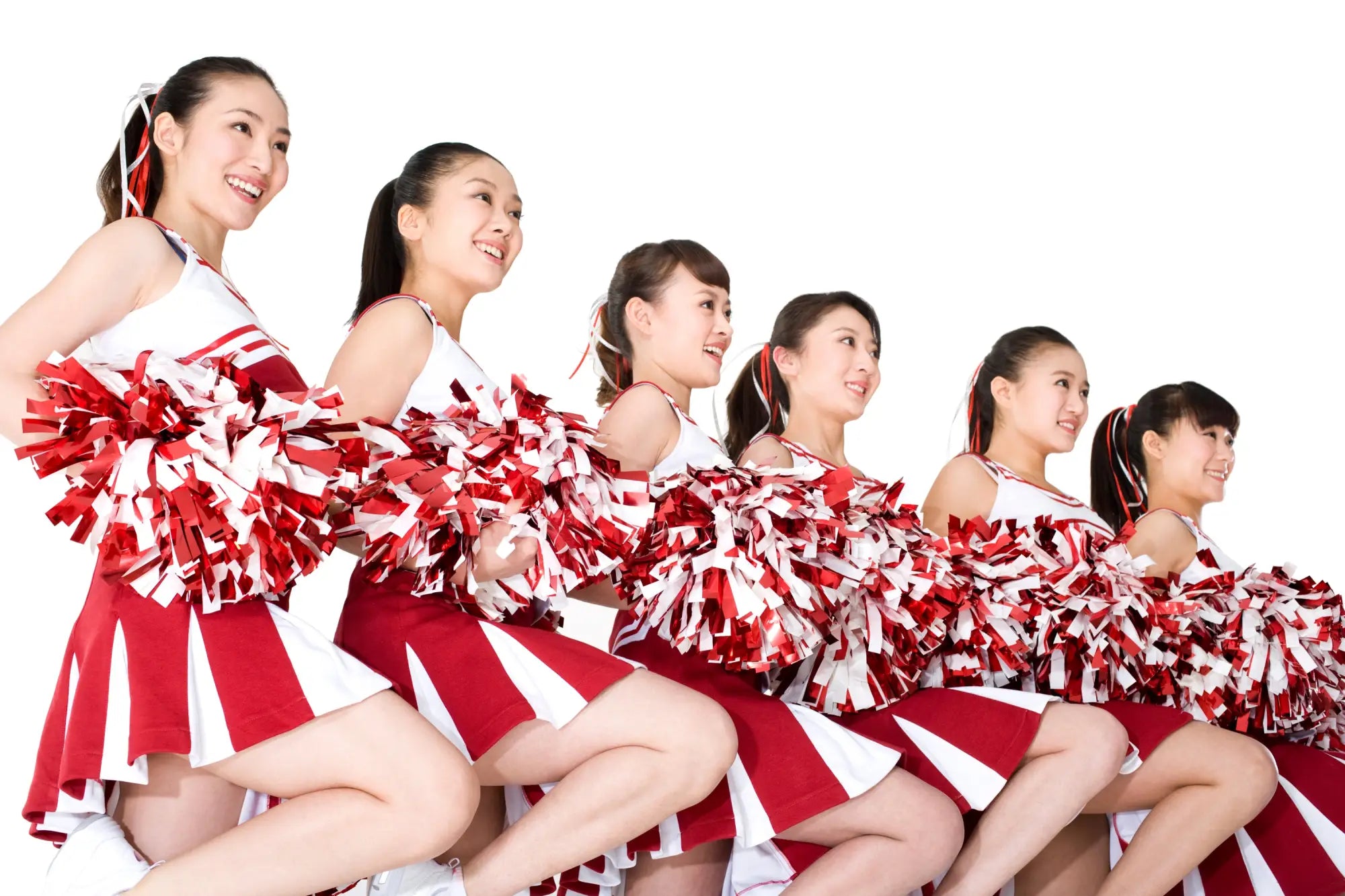 Four cheerleaders in pink cheer hoodies and white shorts posing in a gymnasium.