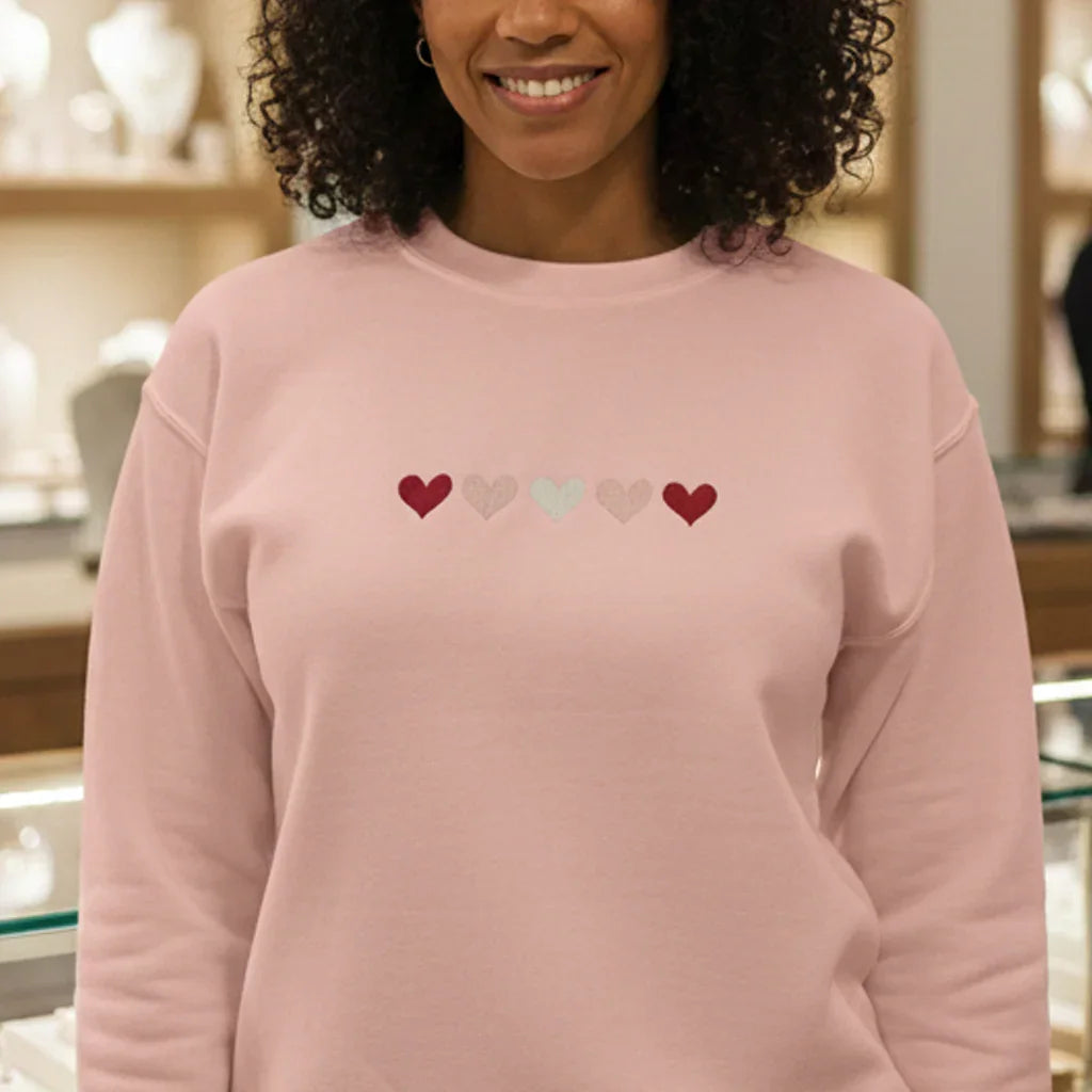 Woman wearing pink embroidered heart sweatshirt from Twist & Thread Co. Valentine's collection