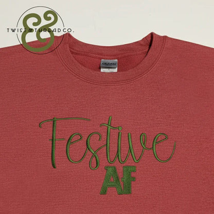 Red Gildan t-shirt with green embroidered text 'Festive AF' and Twist & Thread Co. logo