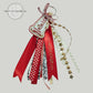 Red personalized bag tag with ribbons, star trim, and embroidered Saxons text by Twist & Thread Co.