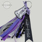 Personalized cheerleading bag tag with purple, black, and silver ribbons, labeled 'Elite'.