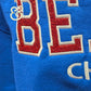Red and white embroidered applique letters on blue fabric, Twist & Thread Co. apparel detail