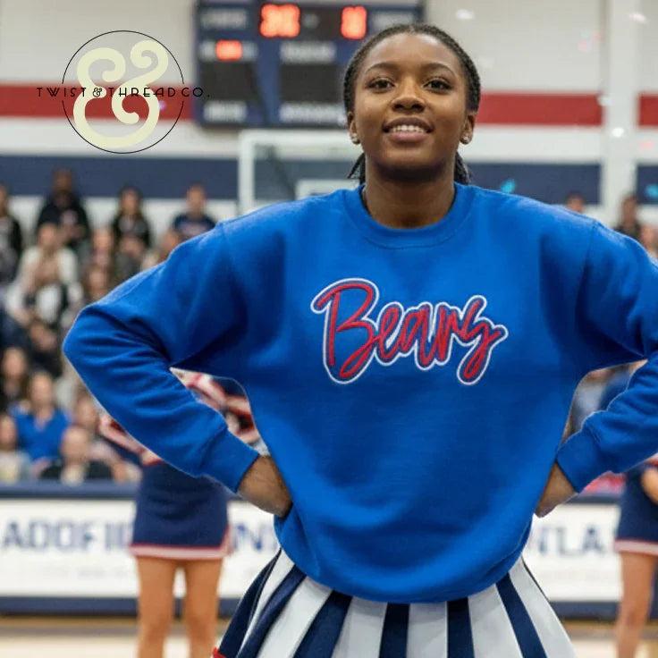 Cheerleader in blue Bears embroidered sweatshirt by Twist & Thread Co. at sports event