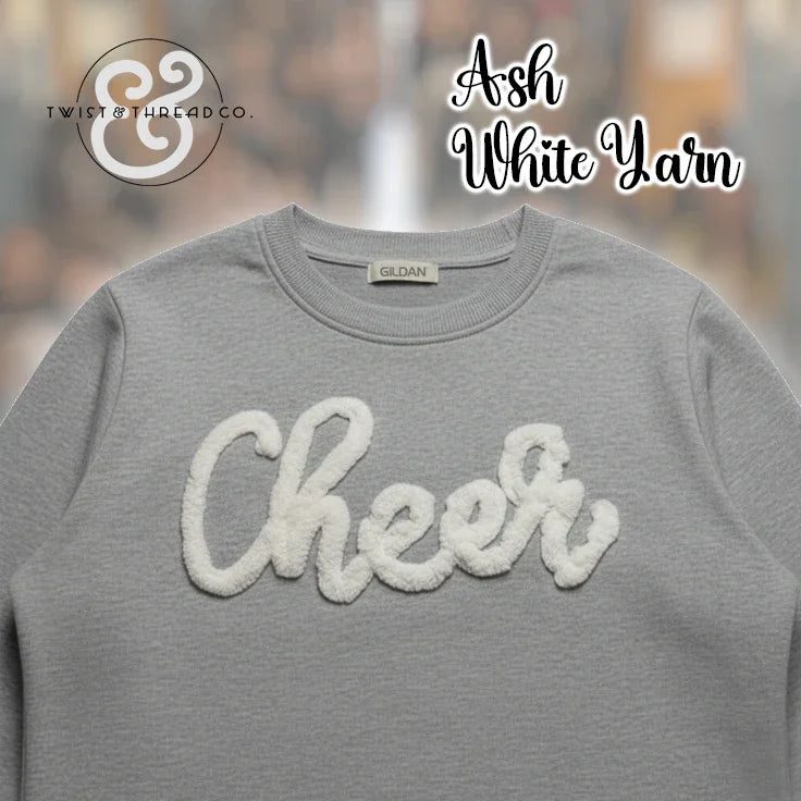 Gray Gildan crewneck sweatshirt with white yarn Cheer text, Twist & Thread Co branding