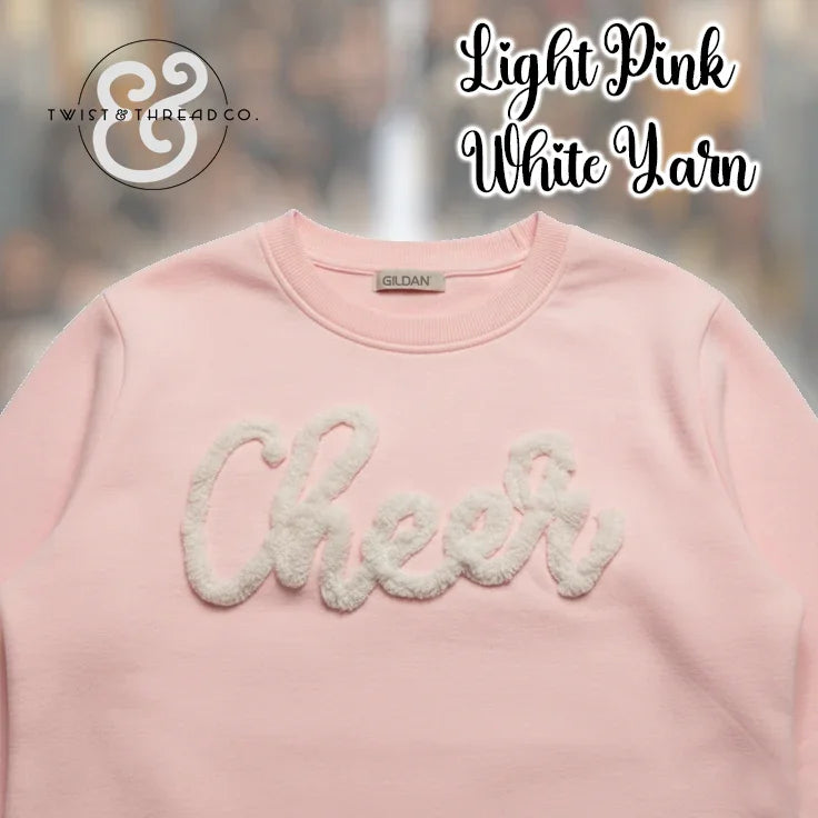 Light pink Gildan crewneck sweatshirt with white yarn 'Cheer' applique