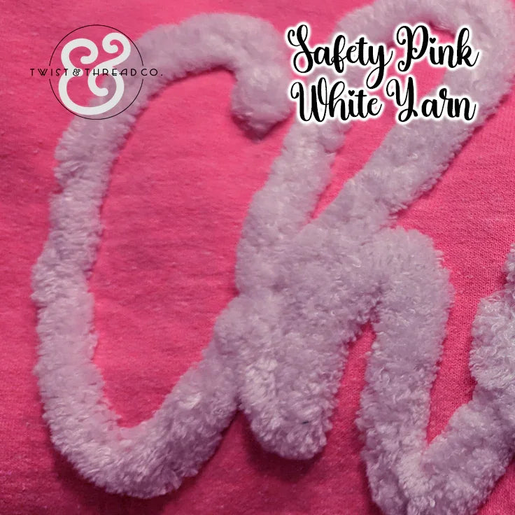 White chenille yarn script on pink fabric, Twist & Thread Co. logo, safety pink yarn.