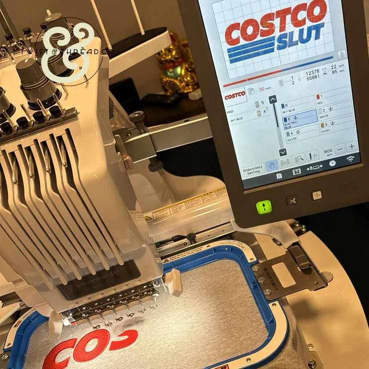Custom embroidery machine stitching red letters on fabric, Twist & Thread Co. workspace
