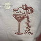 Embroidered cupid pouring hearts into martini glass on white fabric, Twist & Thread Co. design
