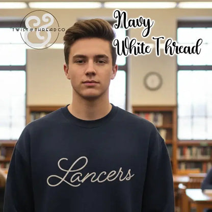 Young man wearing navy sweatshirt with white thread Lancers text in library setting