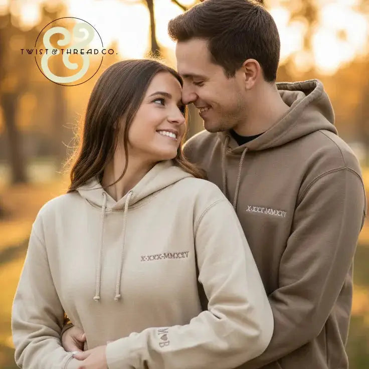 Couple wearing premium embroidered hoodies from Twist & Thread Co. outdoors at sunset