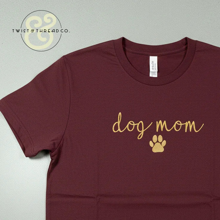 Custom embroidered Dog Mom maroon t-shirt with yellow script and paw print by Twist & Thread Co.