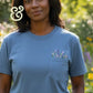 Woman wearing blue custom embroidered t-shirt with floral pocket by Twist & Thread Co.