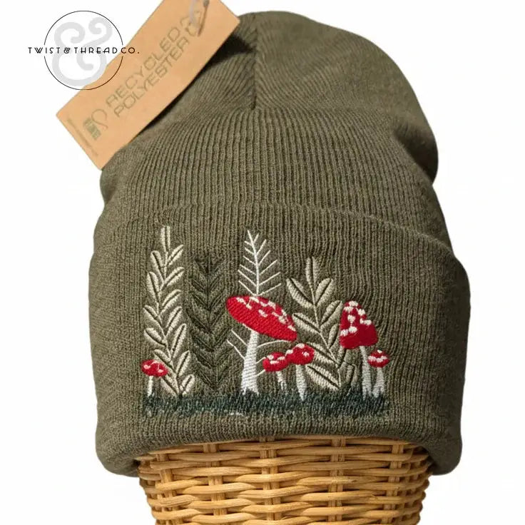 Olive green knit winter hat with embroidered red mushrooms and leaves, recycled polyester tag