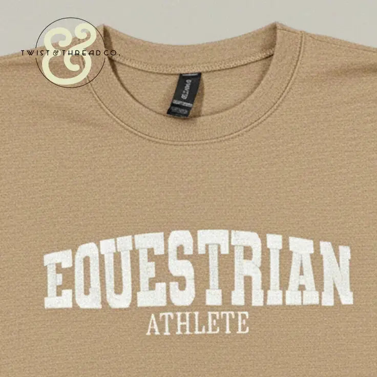 Beige crewneck shirt with white embroidered text 'EQUESTRIAN ATHLETE' from Twist & Thread Co.