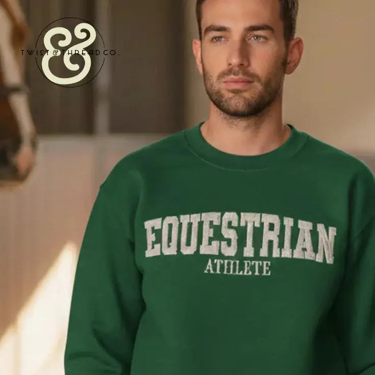 Man wearing green embroidered sweatshirt with EQUESTRIAN ATHLETE text, horse blurred in background