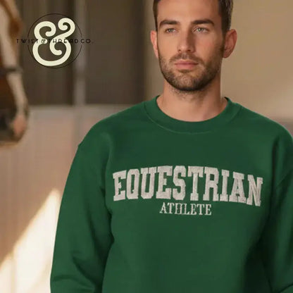 Man wearing green embroidered sweatshirt with EQUESTRIAN ATHLETE text, horse blurred in background