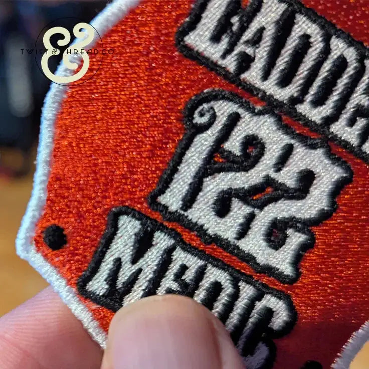 Close-up of embroidered red and white firehouse patch with text Ladder 126 Medic