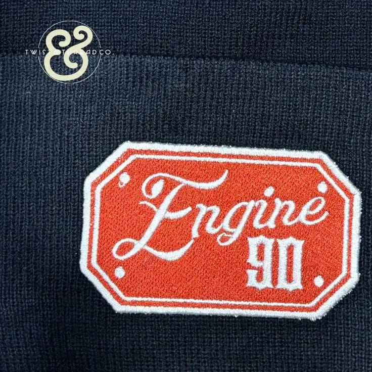 Knitted navy blue fabric with orange and white embroidered Engine 90 badge patch