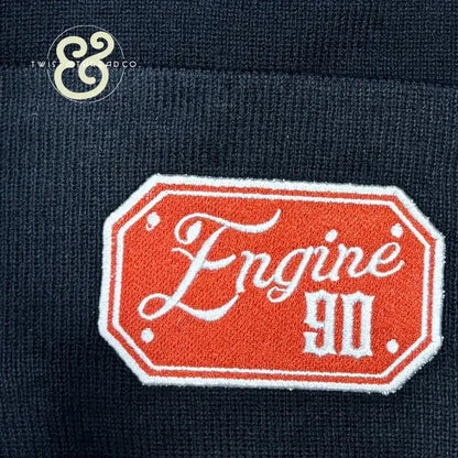 Knitted navy blue fabric with orange and white embroidered Engine 90 badge patch
