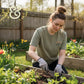 Woman gardening in custom embroidered T-shirt by Twist & Thread Co., raised flower beds