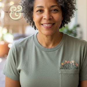 Smiling woman in olive green custom embroidered t-shirt with floral pocket, Twist & Thread Co.