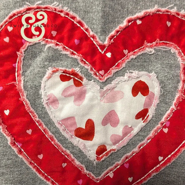 Heart applique embroidery with red and pink hearts on gray fabric, Twist & Thread Co. design.
