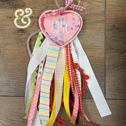 Embroidered pink heart patch with 'LOVE' text, colorful ribbons, Twist & Thread Co. branding