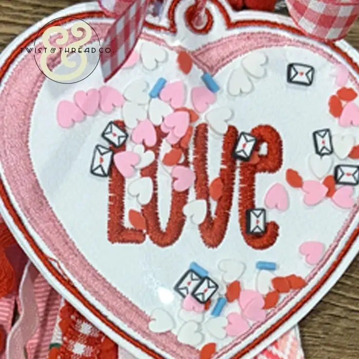 Embroidered heart-shaped LOVE patch with confetti, mini envelopes, and pink gingham ribbon by Twist & Thread Co.