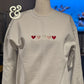 White embroidered sweatshirt with five colored hearts, Twist & Thread Co. premium apparel