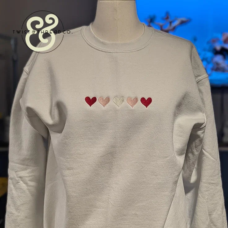 White embroidered sweatshirt with five colored hearts, Twist & Thread Co. premium apparel
