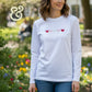 Woman wearing white long sleeve shirt with embroidered hearts, Twist & Thread Co. apparel