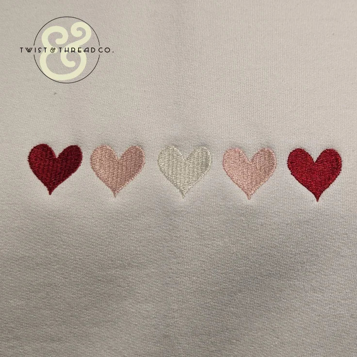 Embroidered hearts on white fabric, Twist & Thread Co. custom apparel design