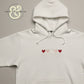 White hoodie with embroidered red and pink hearts, Twist & Thread Co. premium apparel