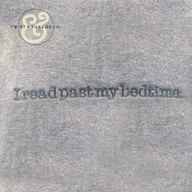 Gray fabric with embroidered text I read past my bedtime in blue thread and Twist & Thread Co. logo