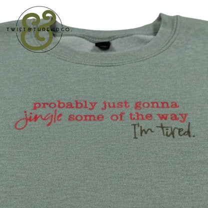 Gray sweatshirt with red and black text reading probably just gonna jingle some of the way I'm tired