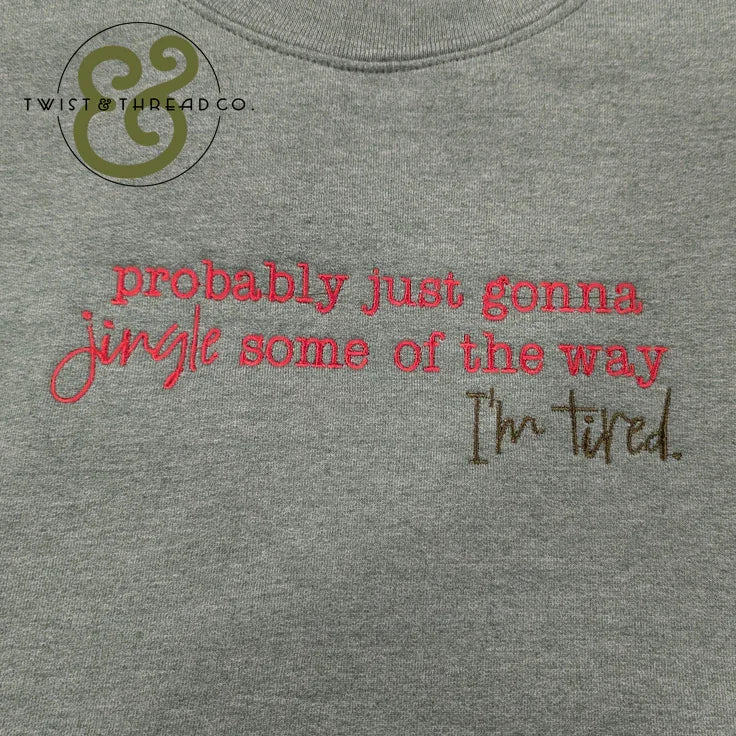 Grey fabric with red and brown embroidered text reading 'probably just gonna jingle some of the way I'm tired'