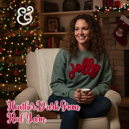 Woman in heather dark green sweater with red 'jolly' yarn, sitting by Christmas tree and fireplace