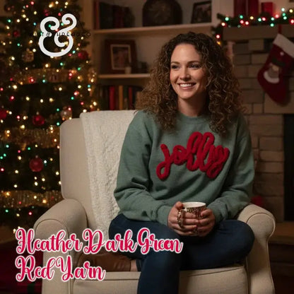 Woman in heather dark green sweater with red 'jolly' yarn, sitting by Christmas tree and fireplace