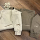 Twist & Thread Co. custom embroidered sweatshirts with initials and Roman numerals on wood floor
