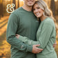 Smiling couple wearing matching green embroidered sweatshirts from Twist & Thread Co. outdoors
