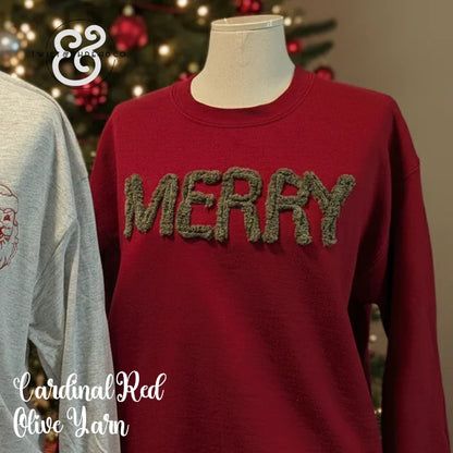 Cardinal red Christmas sweater with green yarn MERRY text, holiday tree in background