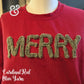 Red sweatshirt with fuzzy olive yarn letters spelling MERRY on a mannequin
