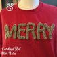 Red sweatshirt with fuzzy olive yarn letters spelling MERRY on a mannequin