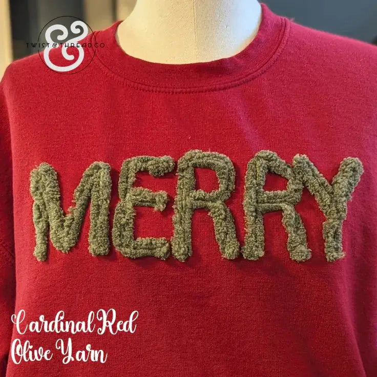 Red sweatshirt with fuzzy olive yarn letters spelling MERRY on a mannequin