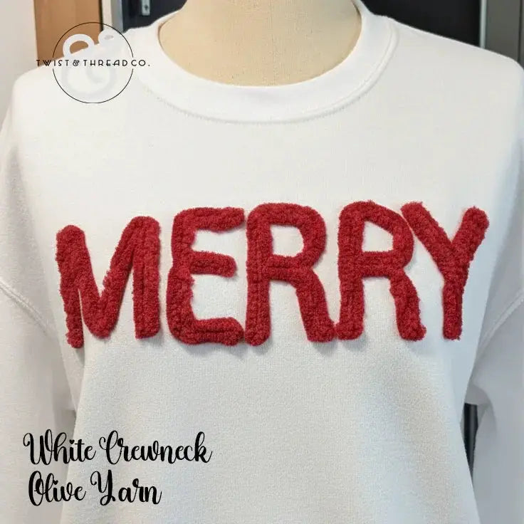 White crewneck sweatshirt with red chenille 'MERRY' text on front, holiday sweater style