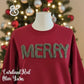 Red sweatshirt with 'MERRY' in green yarn, Christmas tree background, holiday sweater