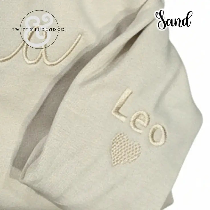Sand-colored fabric with embroidered name 'Leo' and heart, branded Twist & Thread Co.
