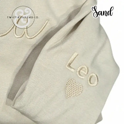 Sand-colored fabric with embroidered name 'Leo' and heart, branded Twist & Thread Co.