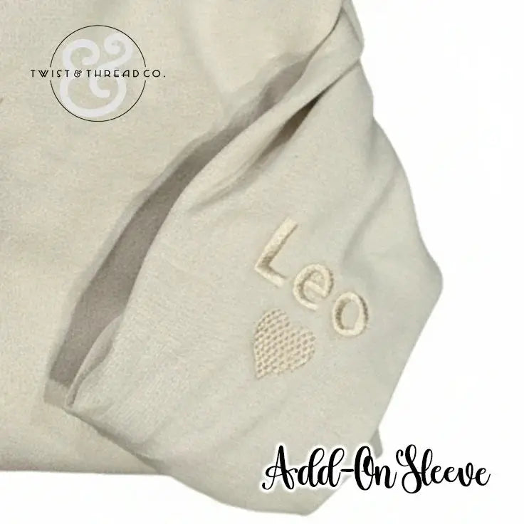 Cream-colored fabric sleeve with embroidered name 'Leo' and heart, branded Twist & Thread Co